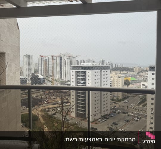 רשת נגד יונים מותקנת על מרפסת עם צמחים